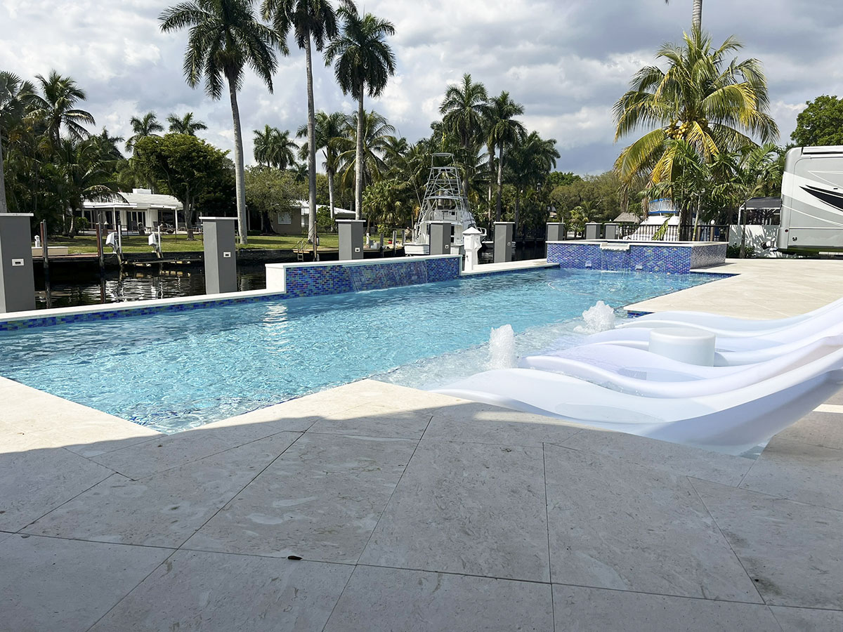 Custom swimming pool with raised spa and tropical landscaping by Rite-Way Pools in Fort Lauderdale, Florida